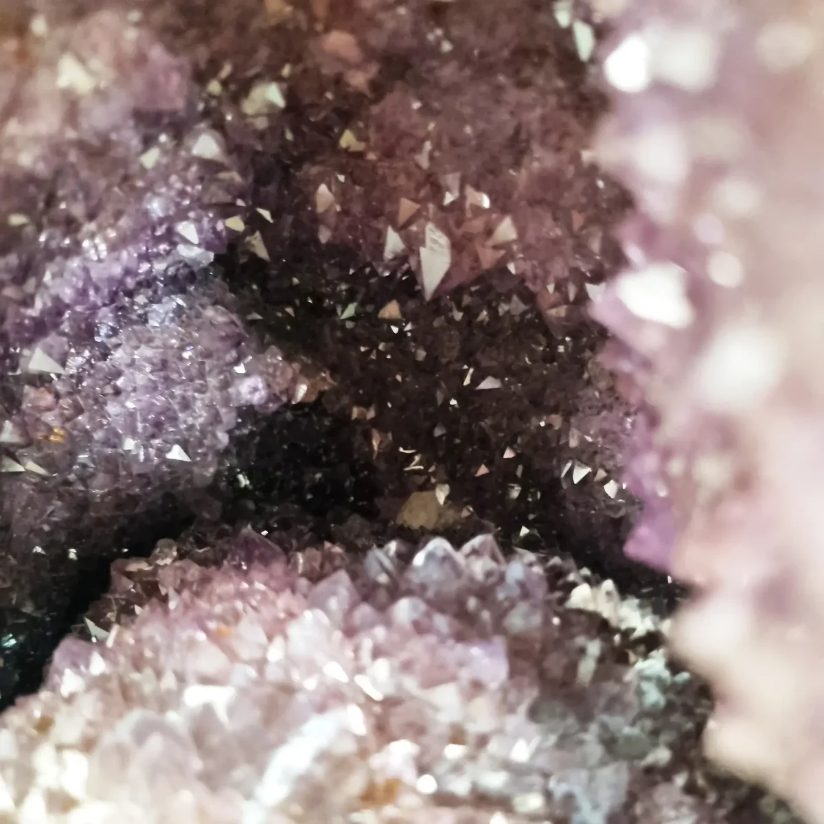 Pogled v notranjost prikazuje osrednjo kristalno komoro geode s sijočo prosojnostjo in naravnim leskom.