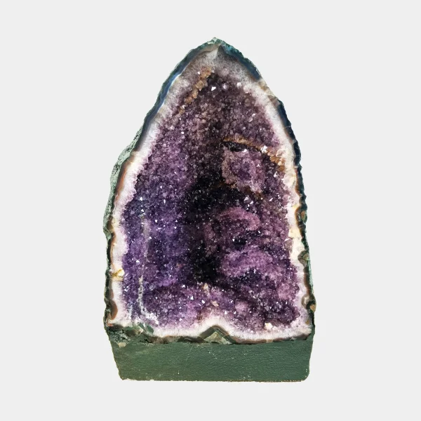 Front view of the 35 cm Amethyst Cathedral revealing rich violet crystals framed by white quartz and smooth basalt edges.