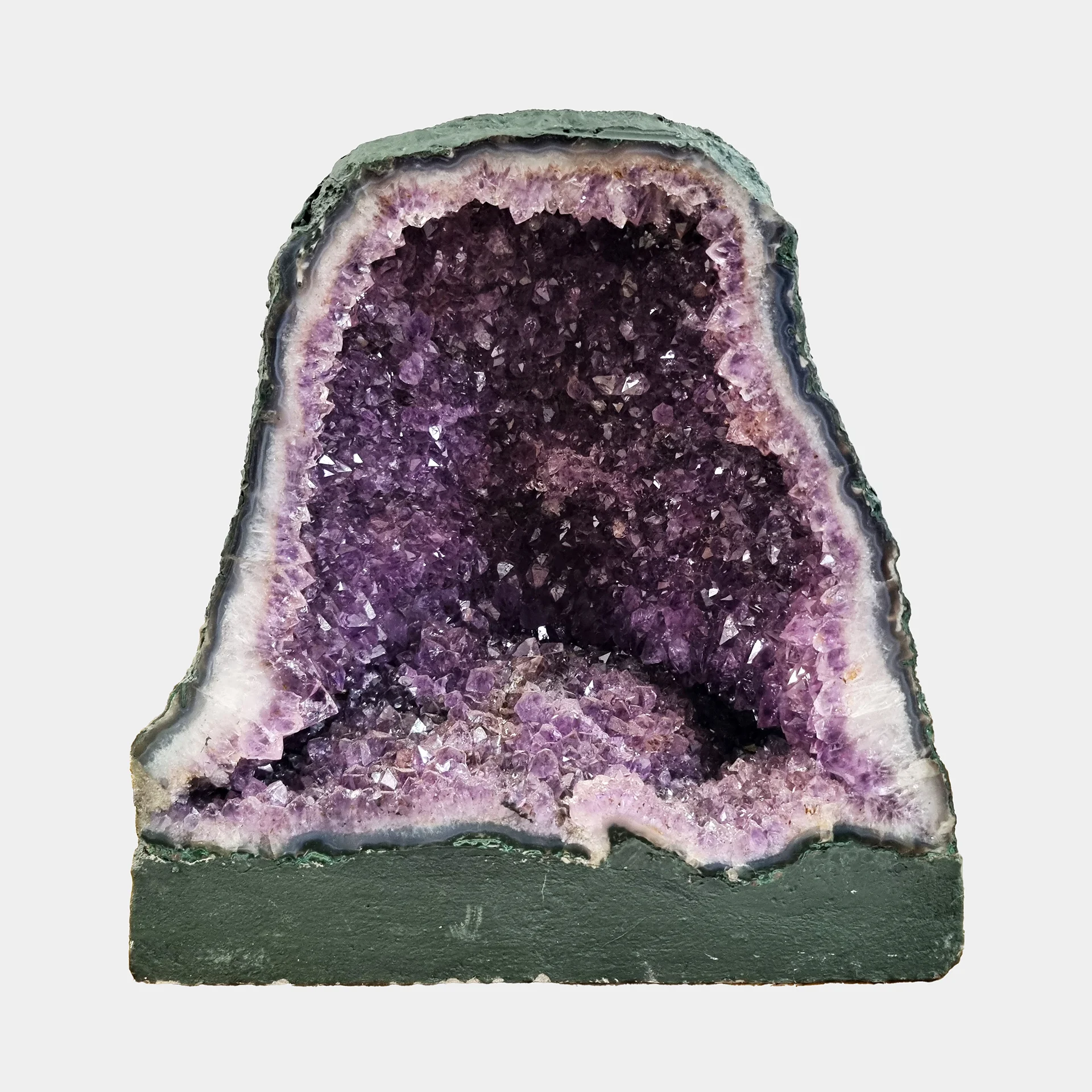 Amethyst Cathedral N°5 – 33 cm – Front View Front view of the 33 cm Amethyst Cathedral revealing deep violet crystal layers framed by pale quartz and smooth basalt base.