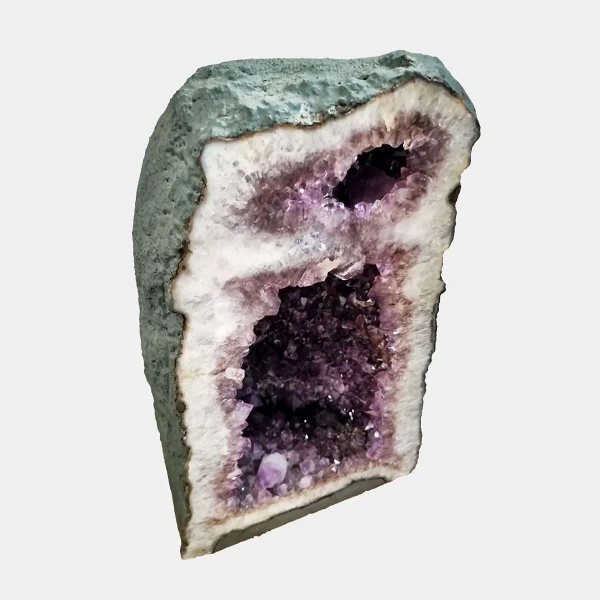 Poševen sprednji pogled poudari bleščečo notranjost kristalov in elegantno zaobljene linije geode.