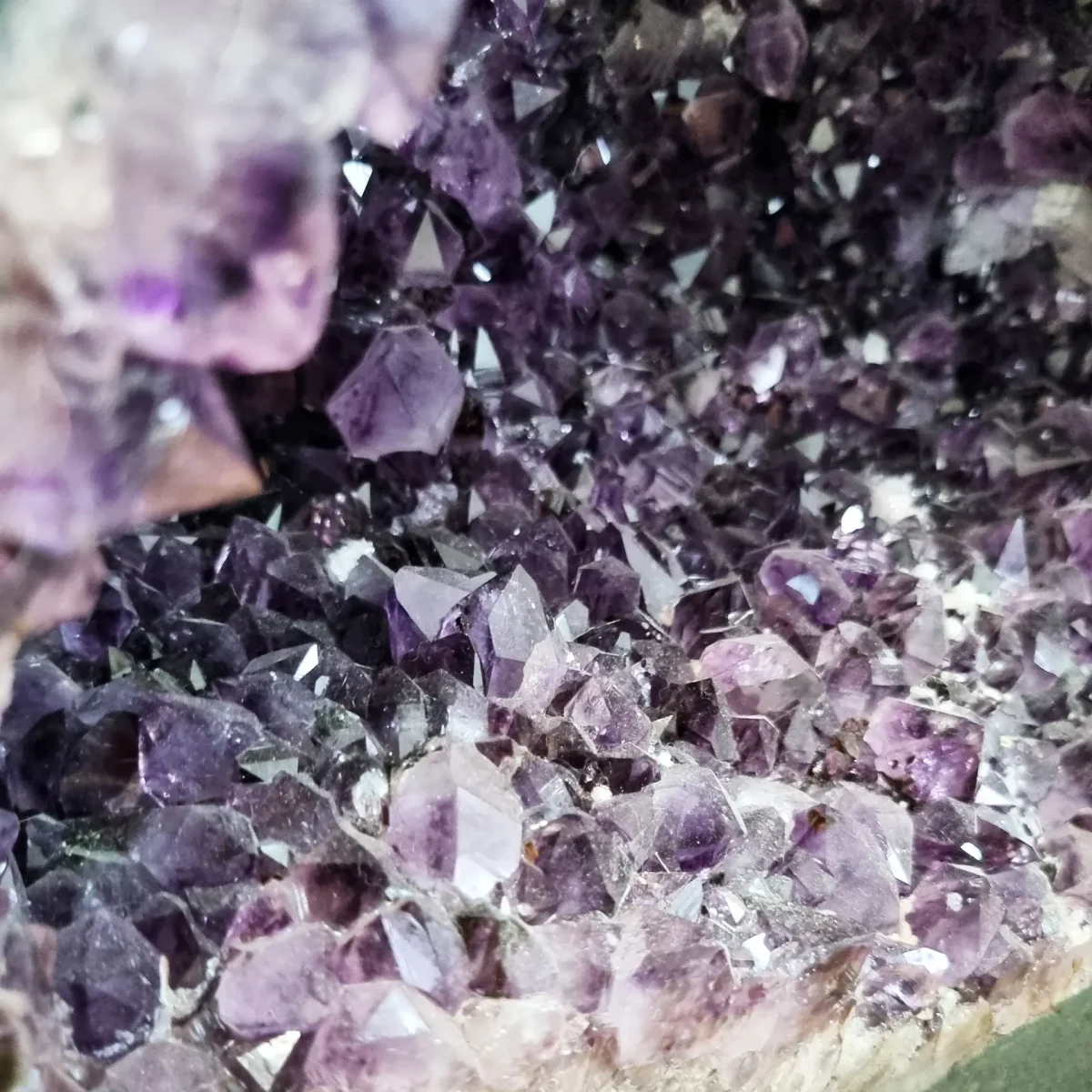 Bližnji pogled razkriva ostrino kristalnih oblik in prelivanje od temno vijolične do svetlejše lila barve.