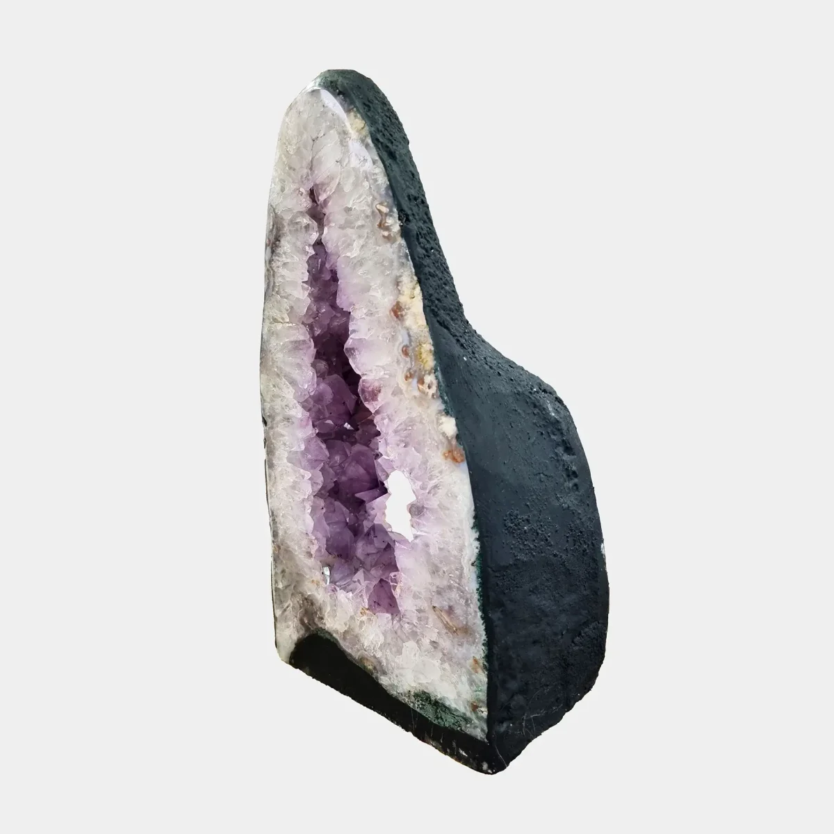 Stranski pogled poudarja elegantno pokončno obliko in odprto strukturo geode z večplastnimi ametistovimi odtenki.