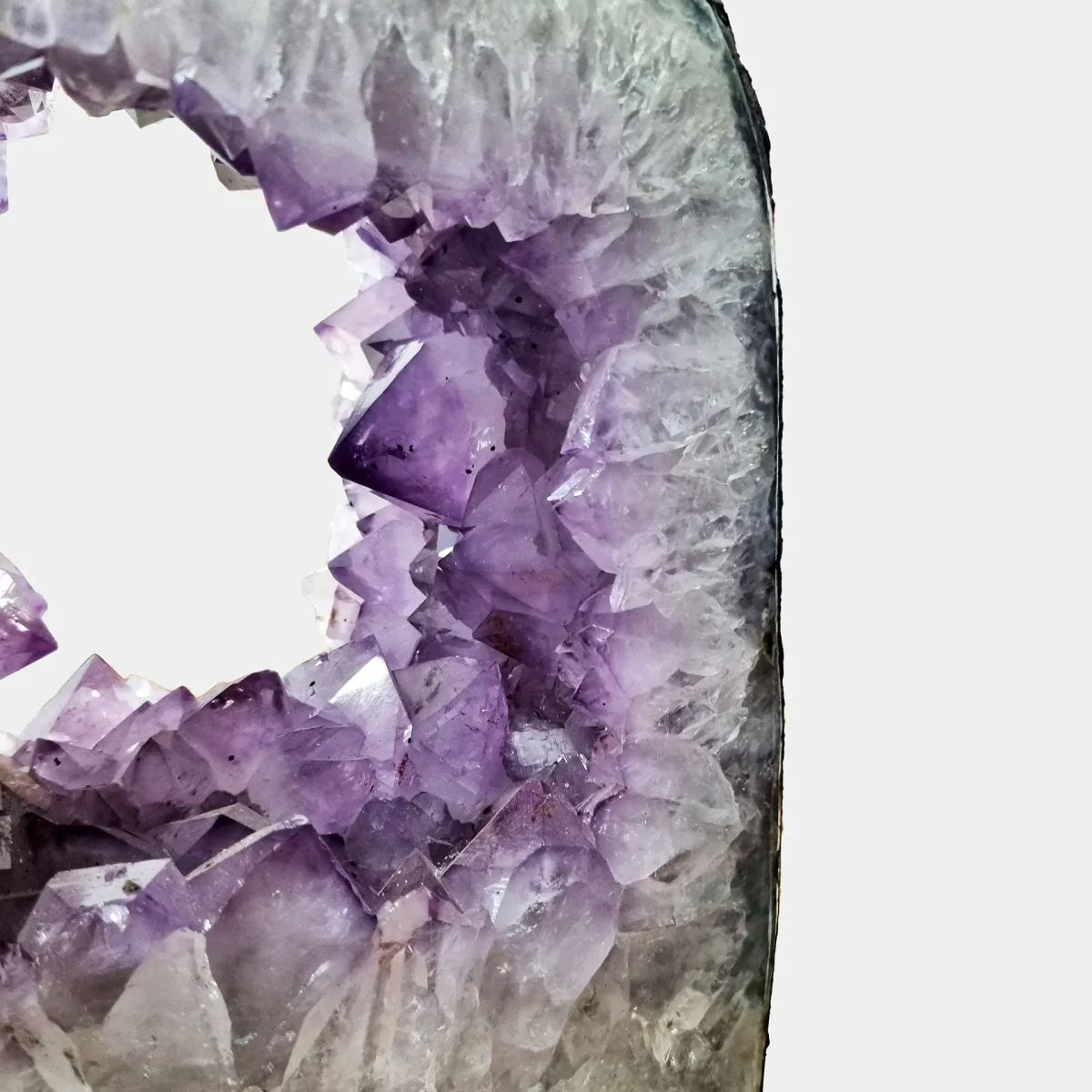 Notranji detajl prikazuje geometrično strukturo kristalov in naravno lomljenje svetlobe v votlini geode.