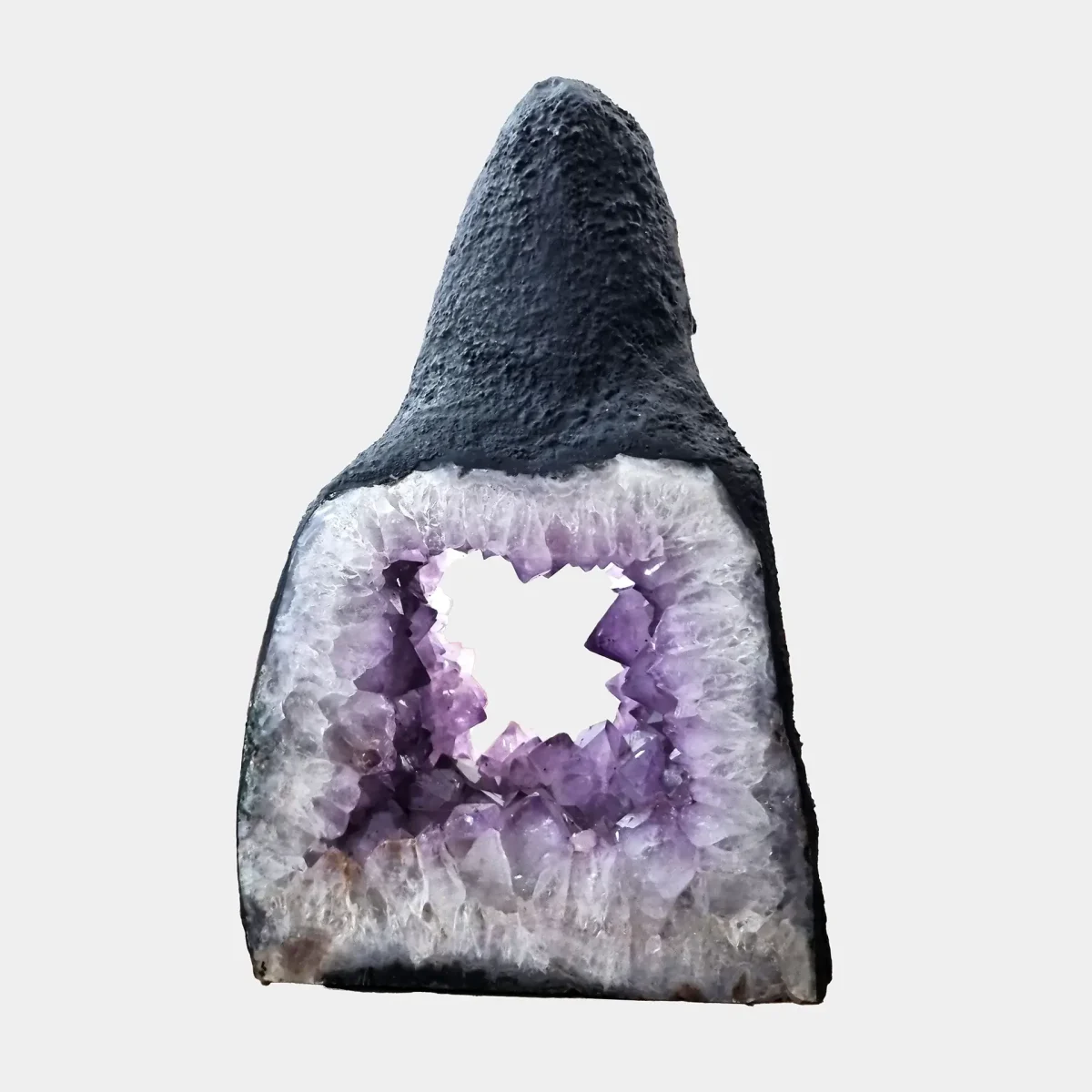 Zadnji pogled razkriva odprt zadnji del votle geode z vidnimi kristalnimi strukturami in bazaltno teksturo.