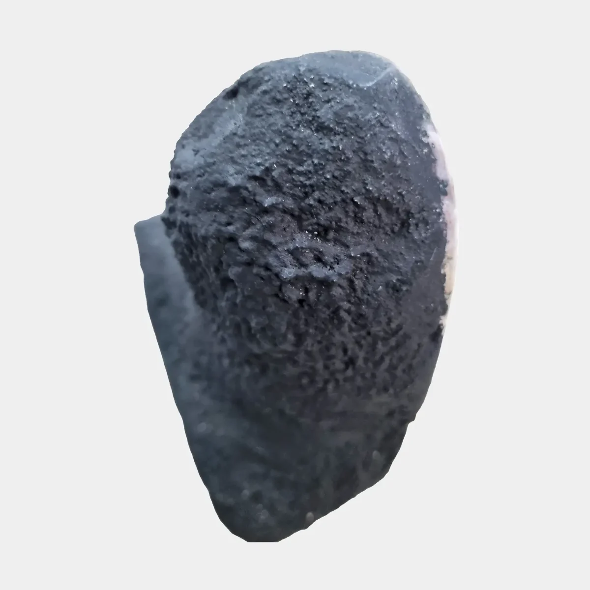 Pogled od zgoraj prikazuje elegantno ožanje oblike in gladko bazaltno površino, ki obdaja kristalno notranjost.