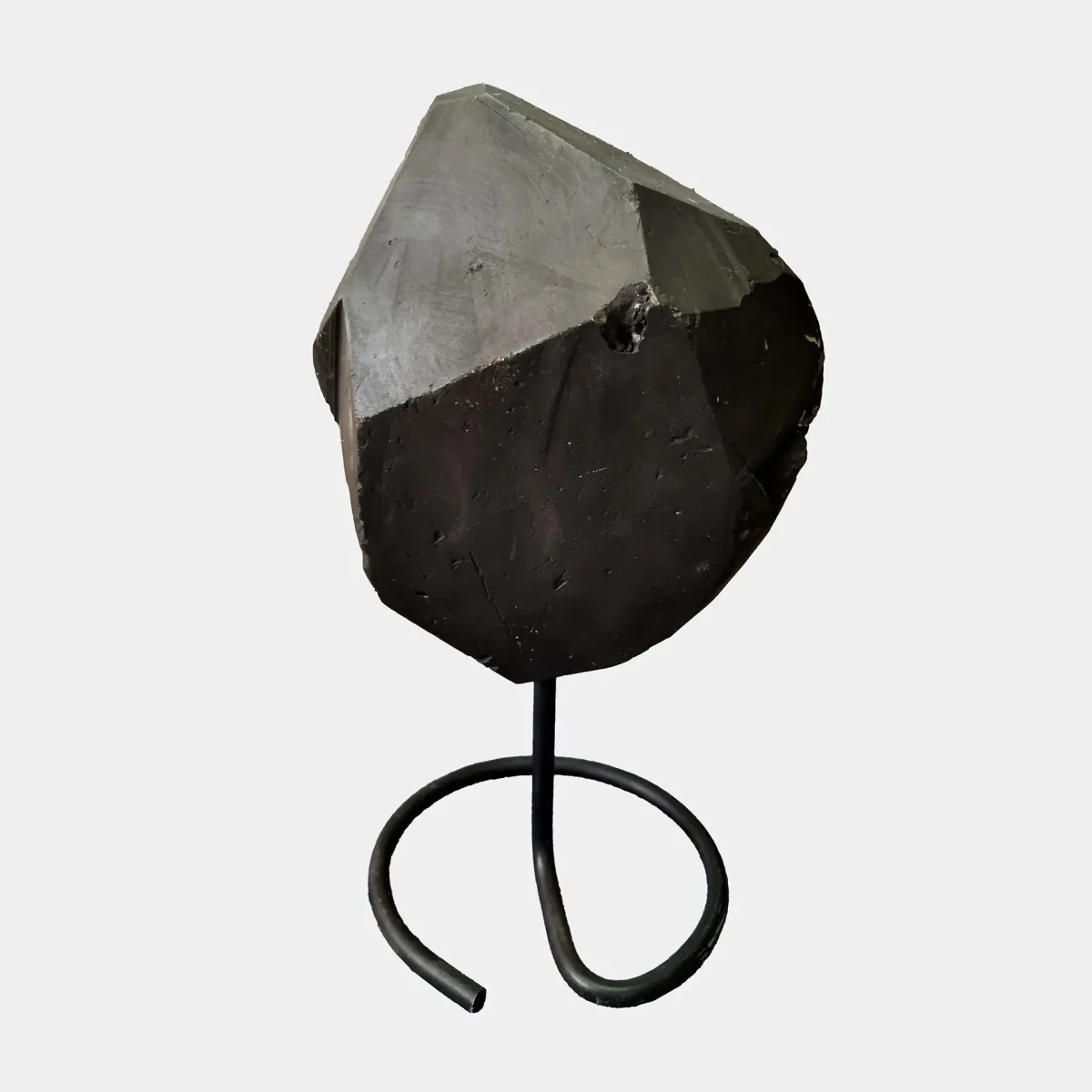 Zadnja stran naravne ametistne geode na črnem kovinskem podstavku, ki razkriva lepo spolirano površino bazalta.