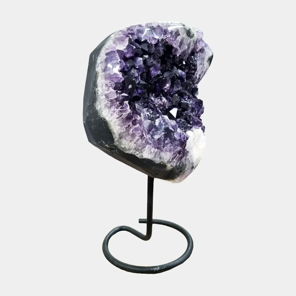 Stranski pogled razkriva skoraj krožno obliko kristalov in globoko vijolično jedro, obrobljeno z belim kremenom.