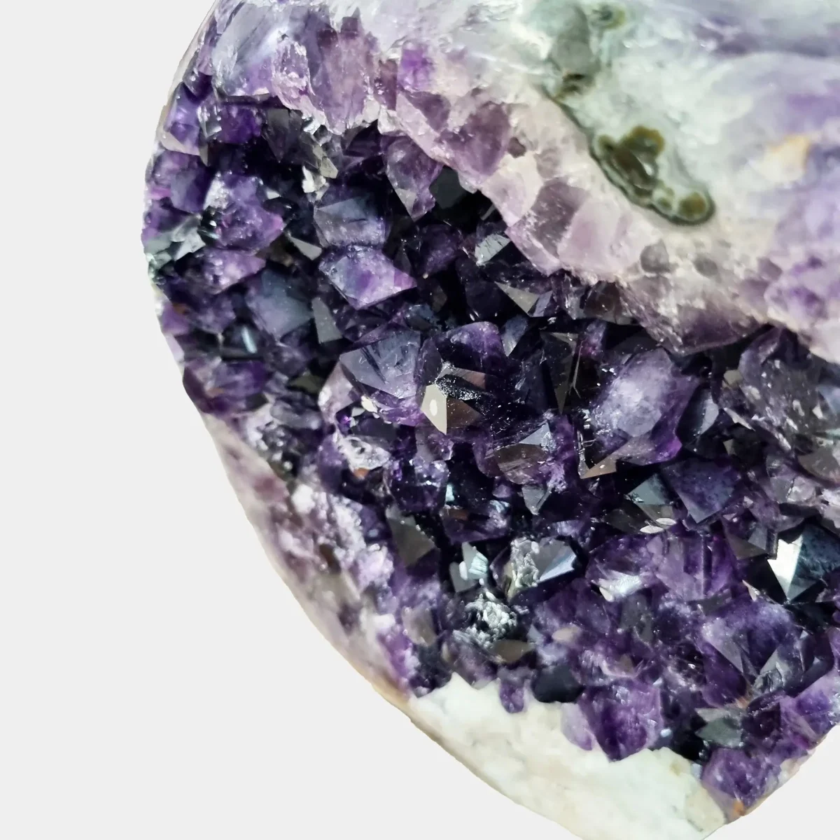 Povečan pogled razkriva bogate odtenke ametista z naravnimi prehodi in čudovitim sijajem v mehki svetlobi.