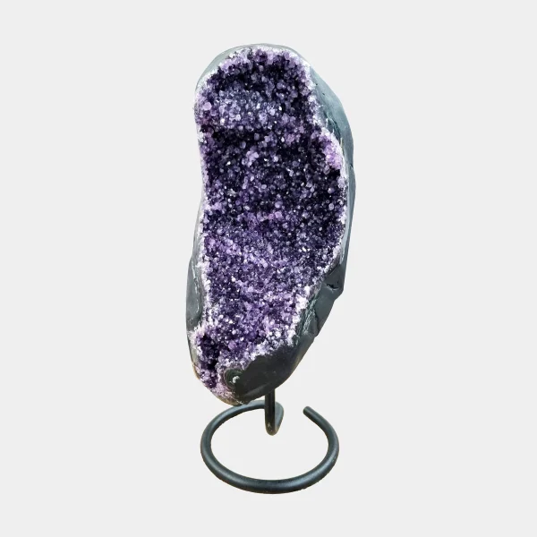 Front view of Brazilian Amethyst on elegant black metal stand, tall curved geode with deep violet crystal interior.