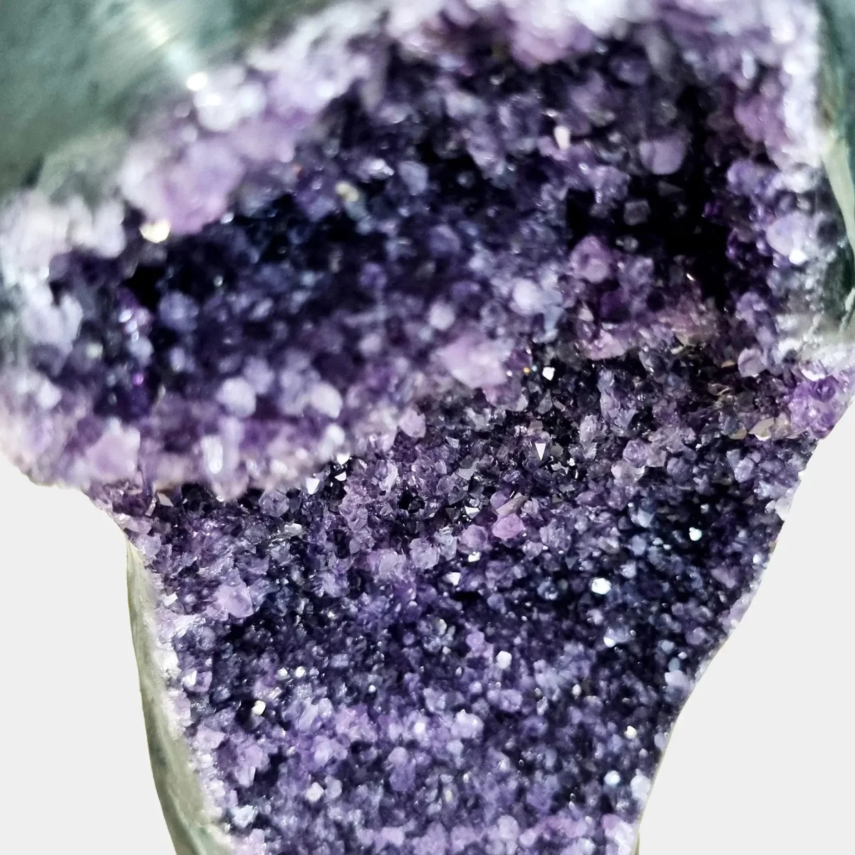 Povečan pogled razkriva gosto zbrane kristale ametista z živahnimi vijoličnimi odtenki in naravnim sijajem.