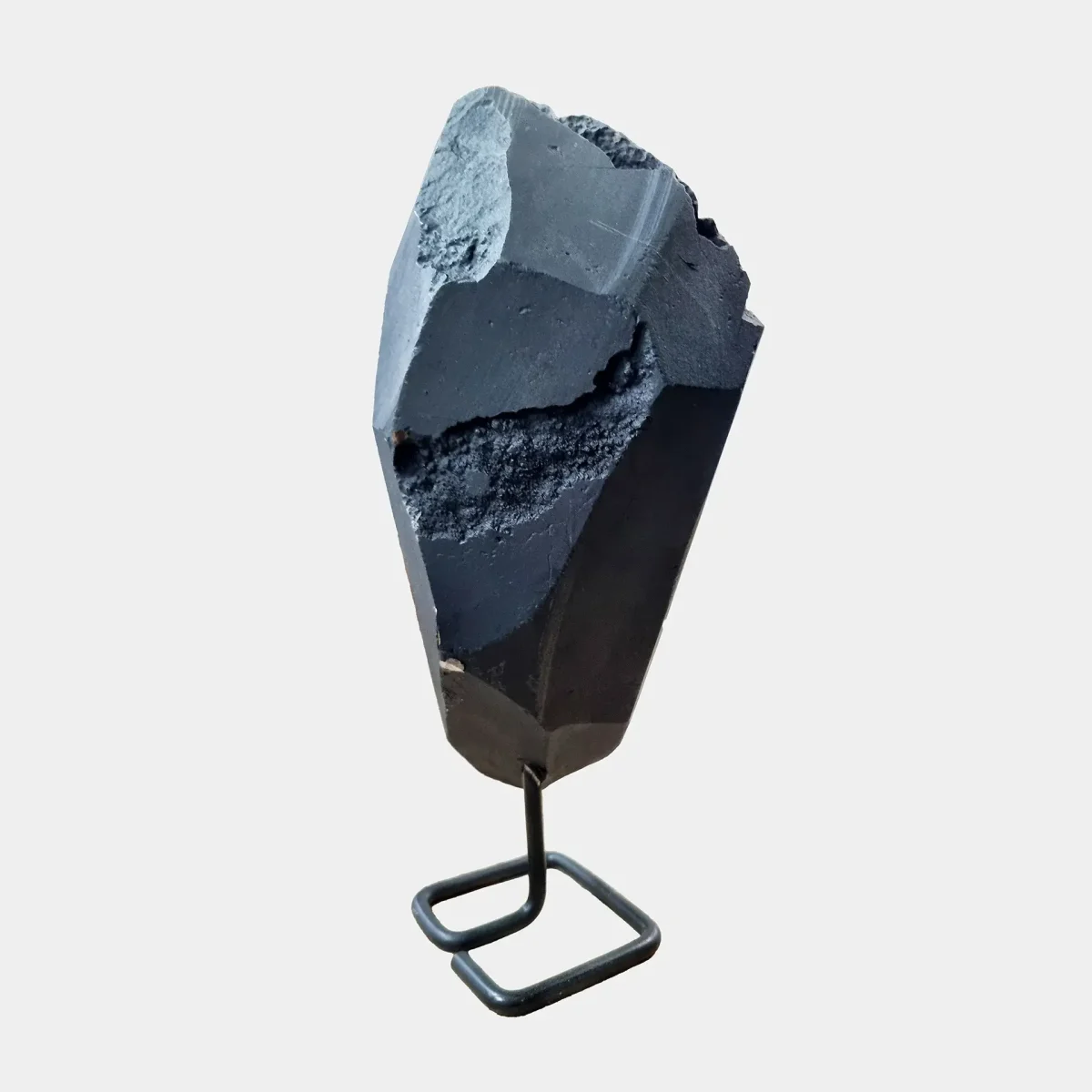 Hrbtni pogled prikazuje gladko bazaltno površino z naravno geometrijo in prefinjenimi linijami kamnine.