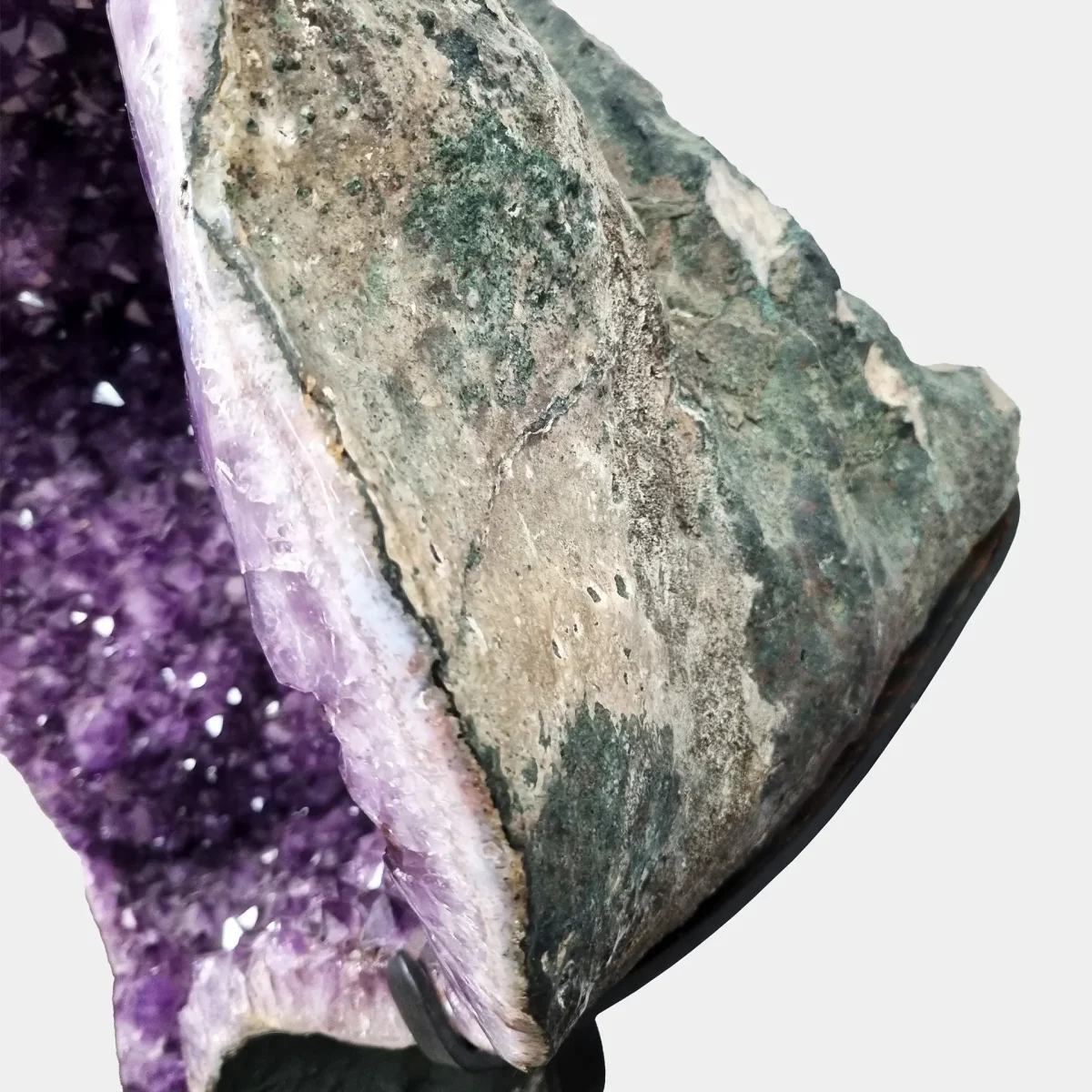 Poševen pogled prikazuje notranji sijaj ametista ter naravno bazaltno zunanjost.