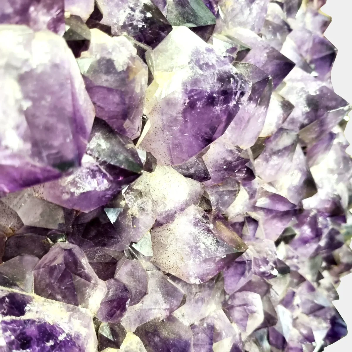 Bližnji pogled na ametistove kristale, ki razkriva njihovo prefinjeno strukturo in globoke vijolične odtenke.