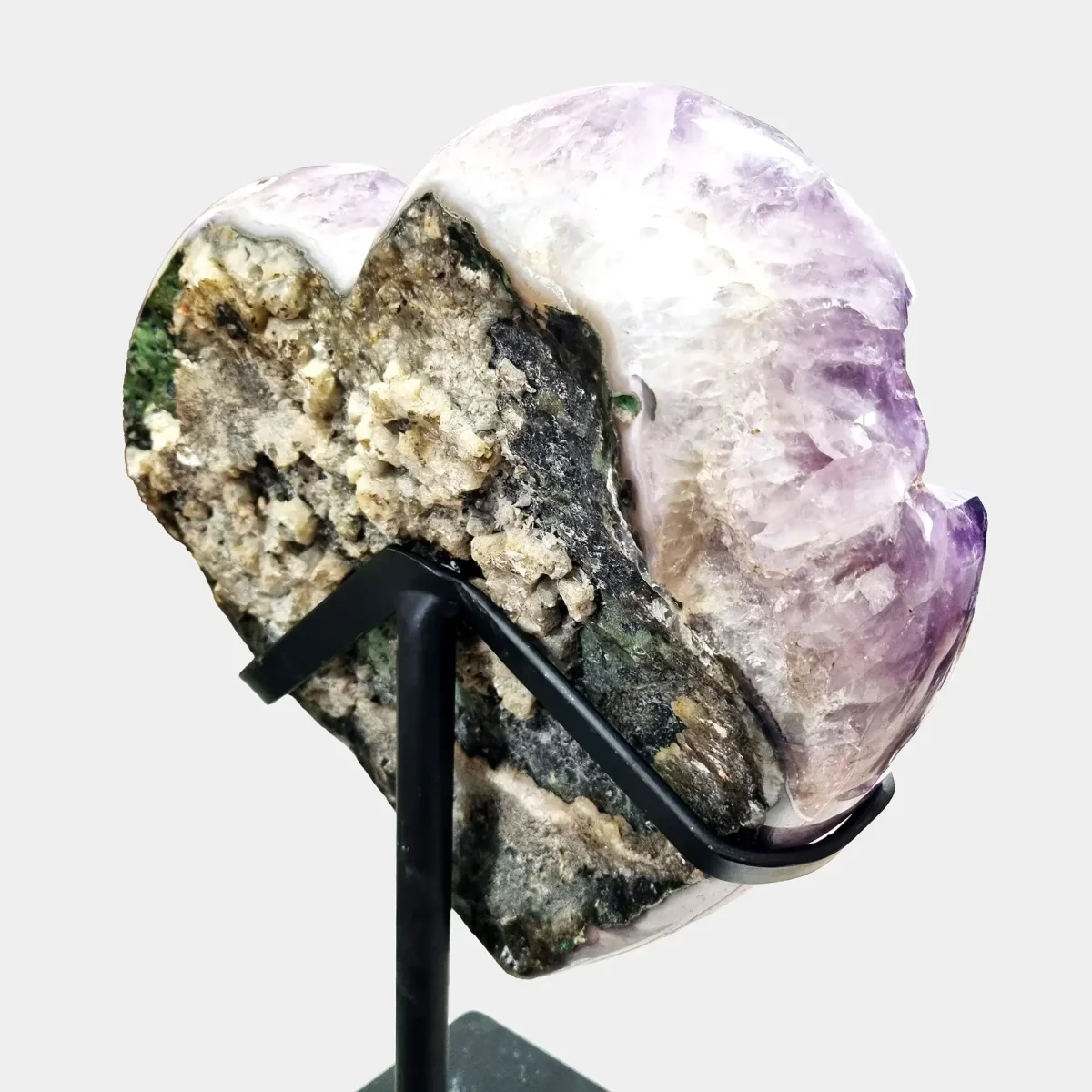 Poševen zadnji pogled na ametistov grozd, ki lepo izpostavi naravne teksture in značilno oblikovanje mineralne matrice.