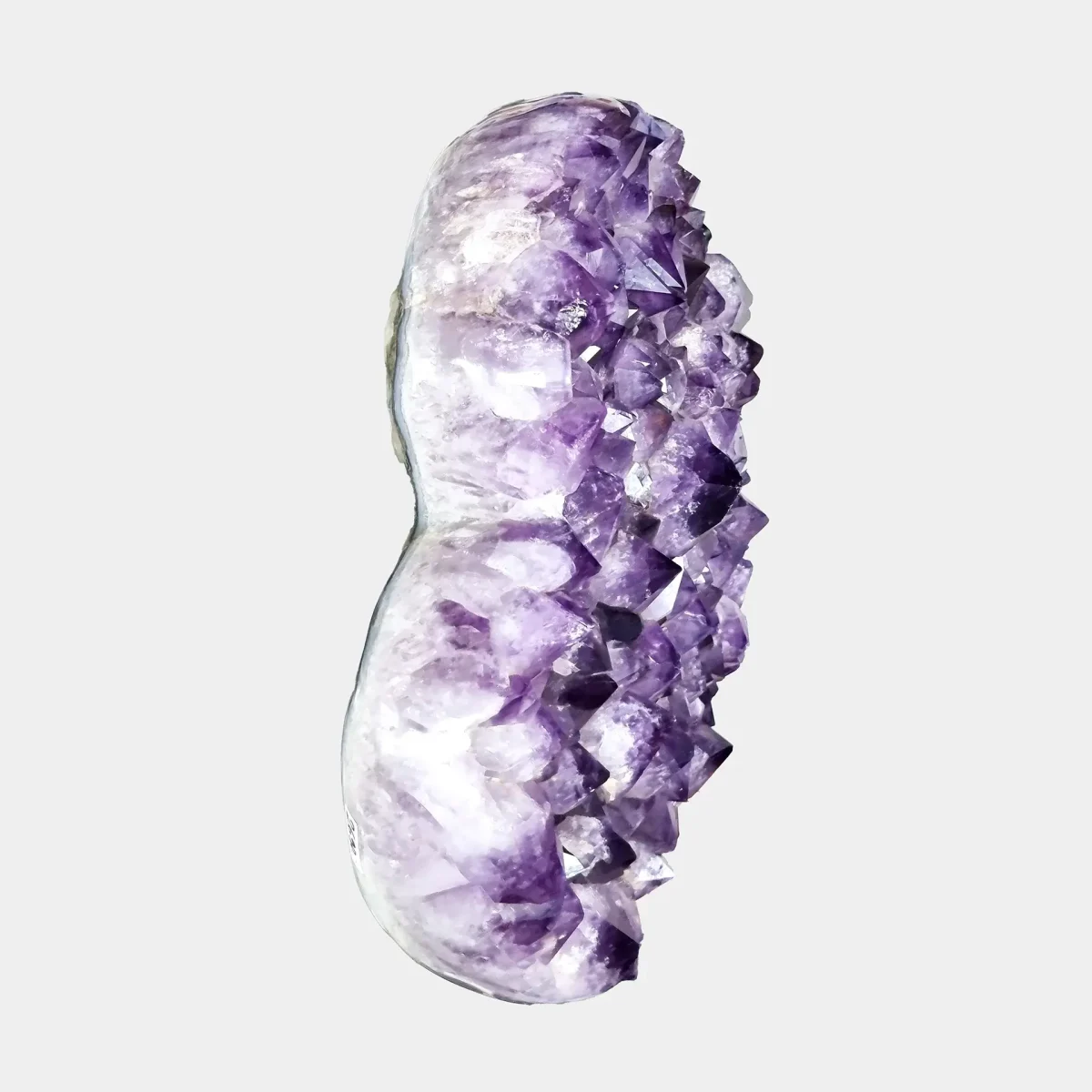 Pogled od zgoraj na srčasto oblikovan ametistov grozd, kjer se jasno vidi globina kristalov in naravna ukrivljenost geode.