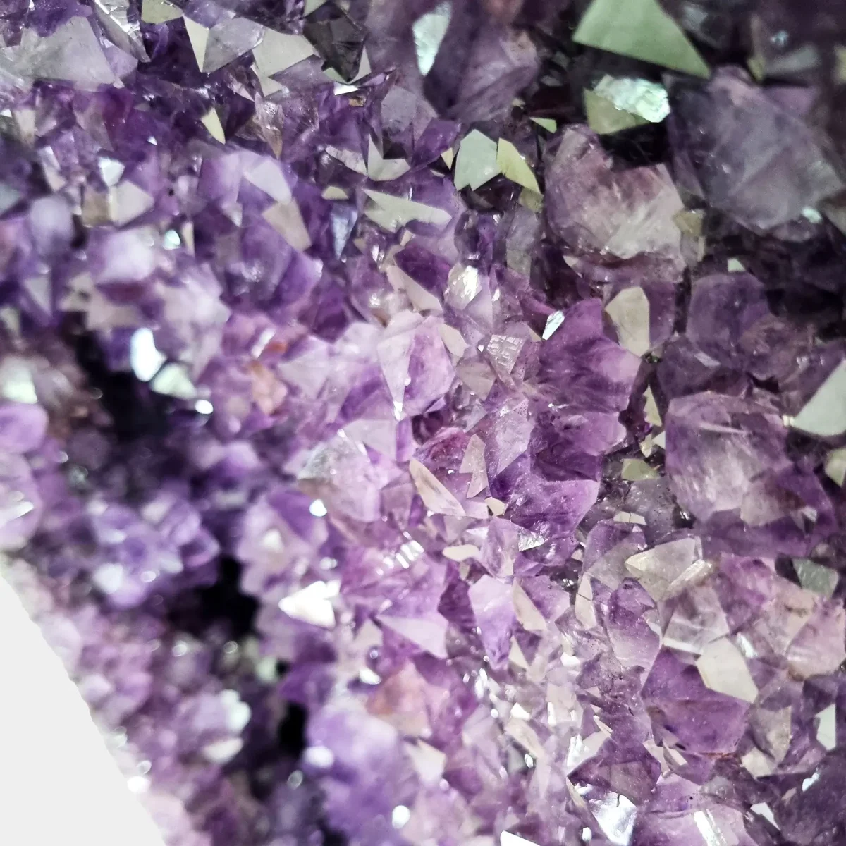 Makro pogled na bleščeče kristalne konice, ujete v naravne odseve svetlobe.