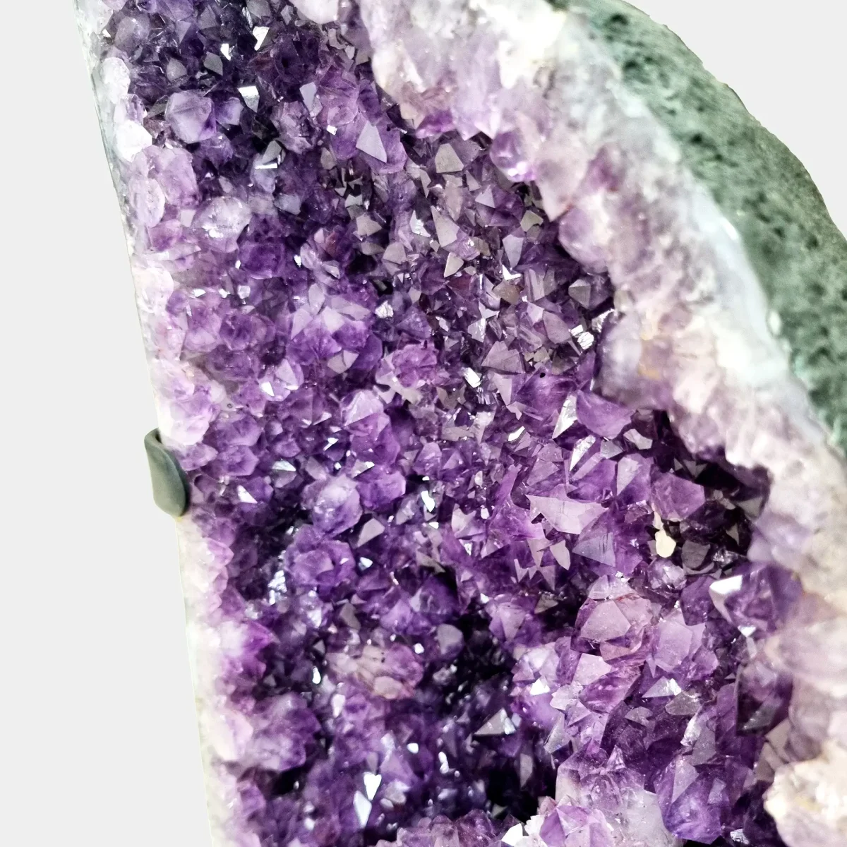 Podroben pogled na kristalno površino, kjer se prelivajo globoki vijolični odtenki in izrazita tekstura ametista.