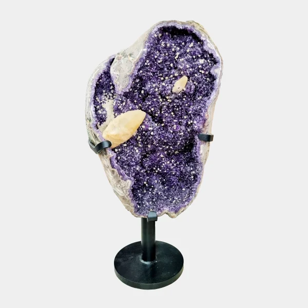 Front view of a tall Amethyst geode with Calcite inclusions on a black stand showcasing deep violet crystals.