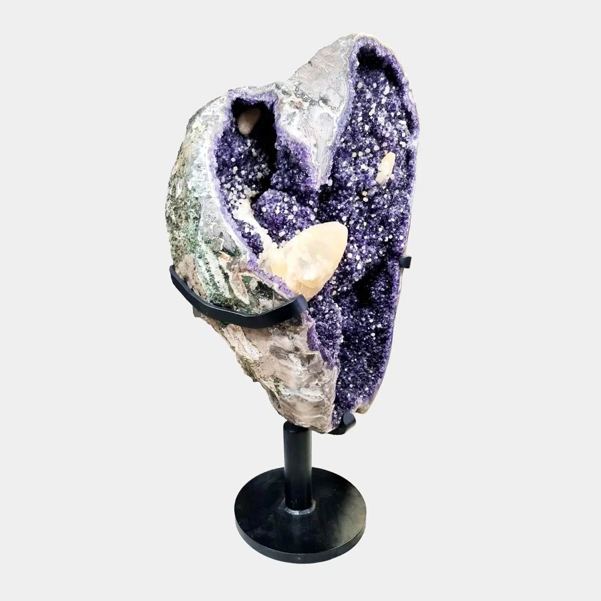 Drugi stranski pogled, ki izpostavi rahlo ukrivljeno obliko geode in kristalno bogato notranjost.