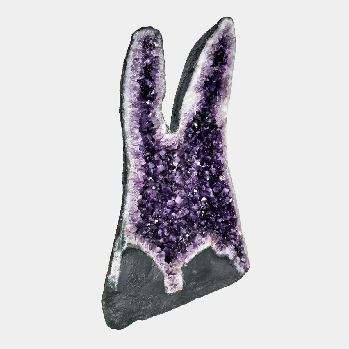 Stranski pogled, ki razkriva globino, naravne linije in kristalno strukturo visoke ametistove formacije.