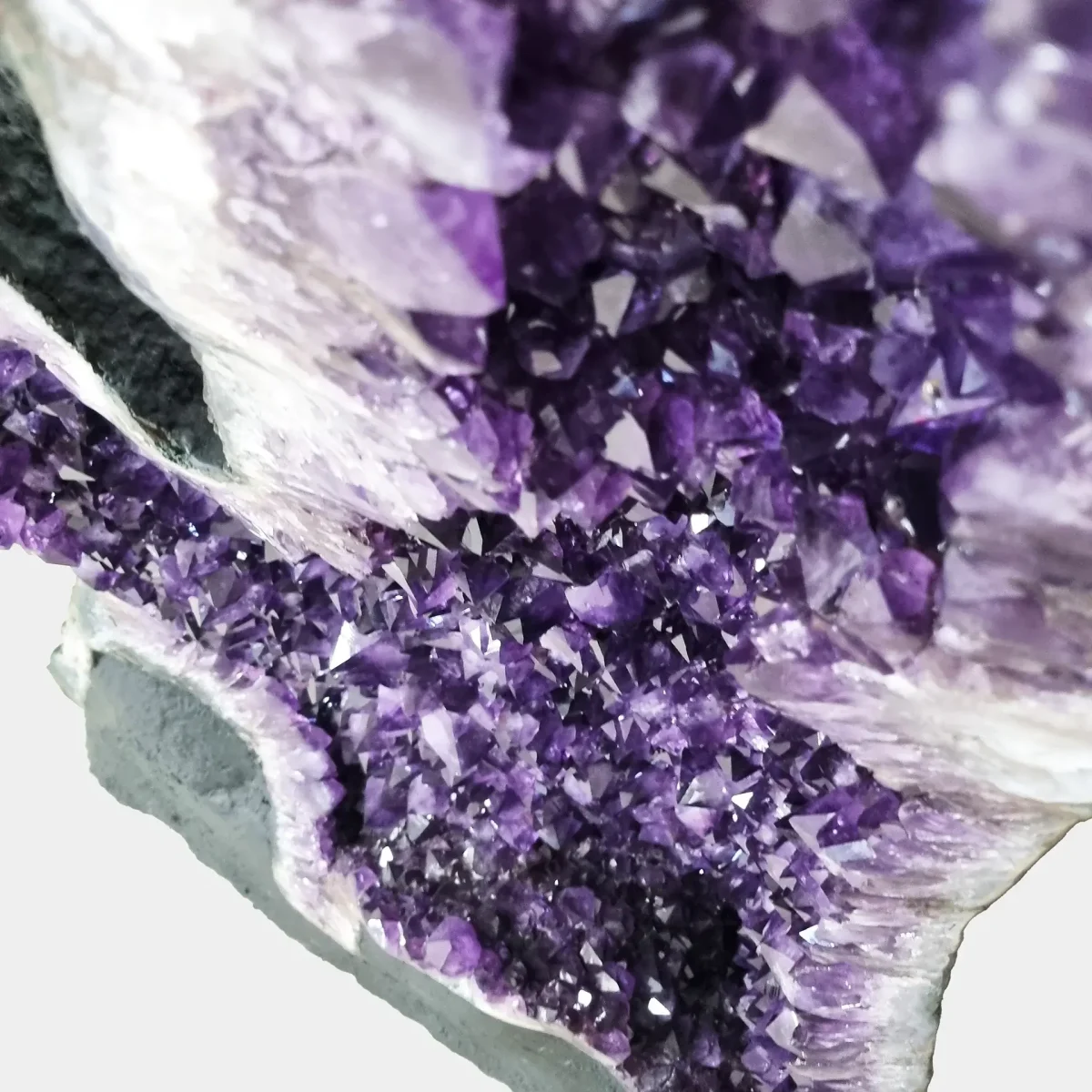 Bližnji pogled od zgoraj, ki razkrije drobne ametistove kristalne konice in izrazito globino v notranjosti geode.