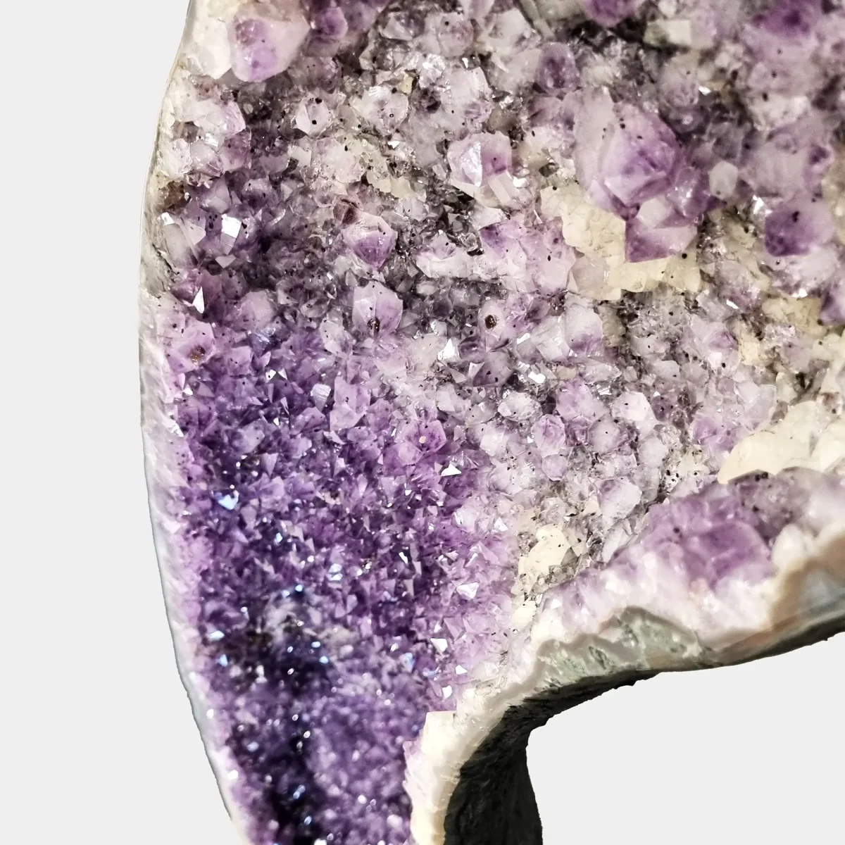 Podroben zgornji bližnji pogled na ametistove kristale, kjer se nežni lila prehodi stapljajo v globoke vijolične tone.