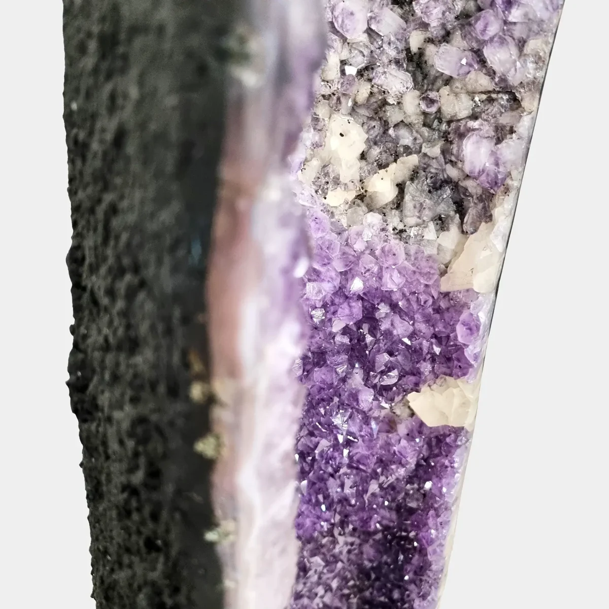 Stranski bližnji posnetek notranjosti ametistovih kristalov, ki ujame njihovo teksturo, čistost in naravno pasovitost.