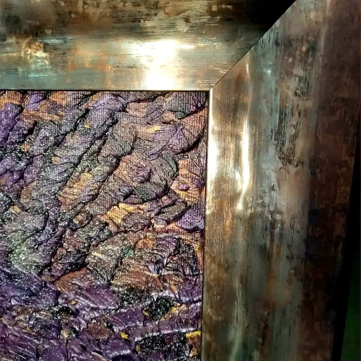 Corner detail of the frame with textured painted surface in violet and bronze tones