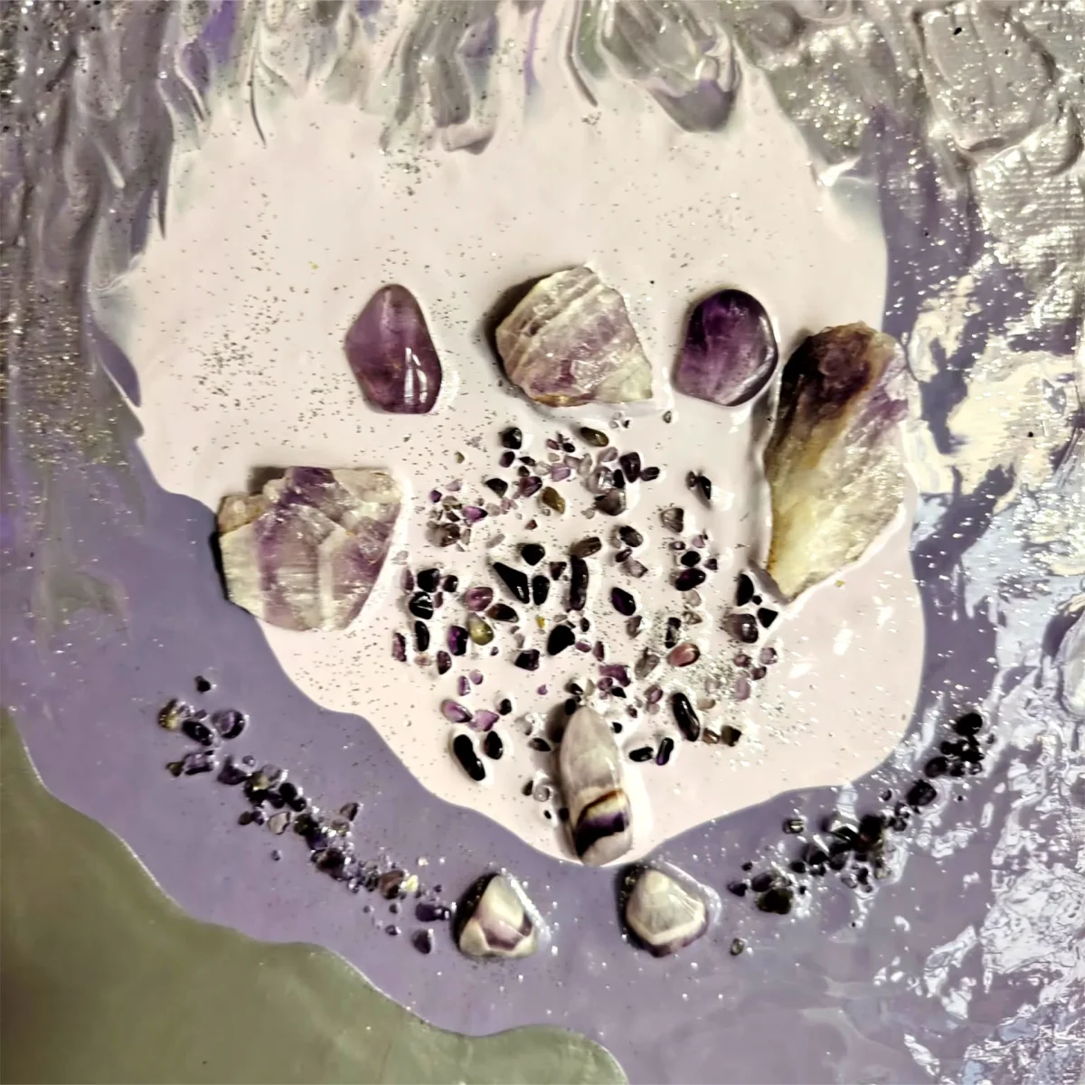 Close-up of a polished amethyst stone set into a soft metallic surface