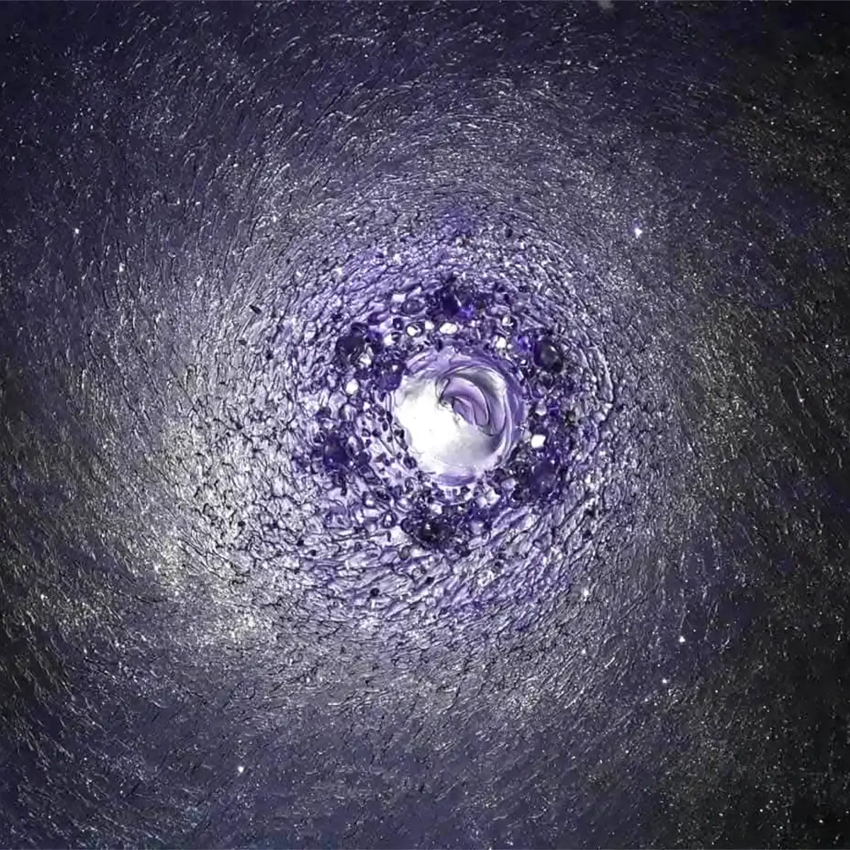 Bližnji pogled na osrednjo spiralo s slojevito vijolično barvo in vdelanimi ametisti