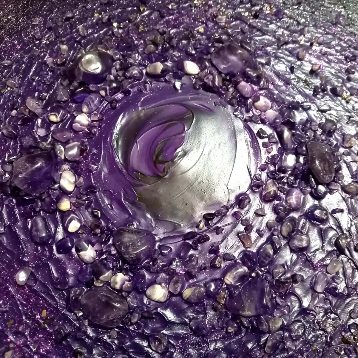 Detajl površine s sijočimi temnimi toni in teksturiranim spiralnim gibanjem