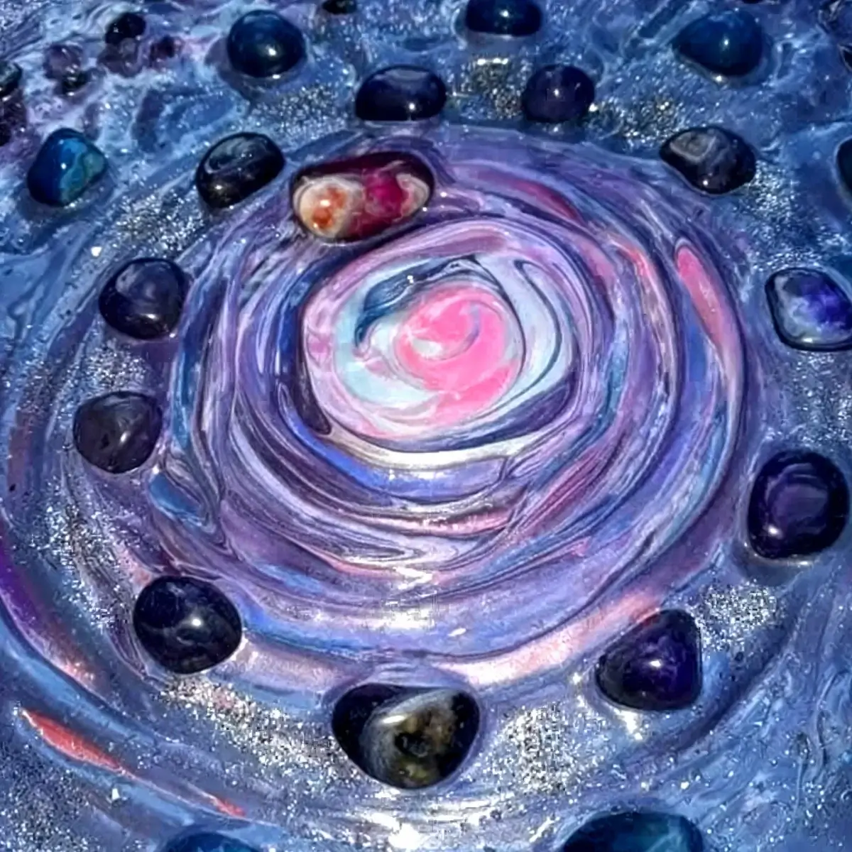 Close-up of the luminous centre with swirling pink, violet, and blue paint