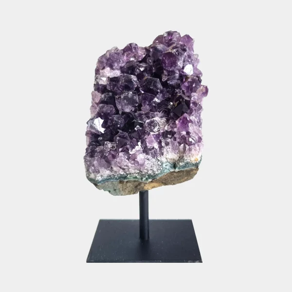 Front view of an amethyst cluster on a black metal stand with dark violet crystal points.