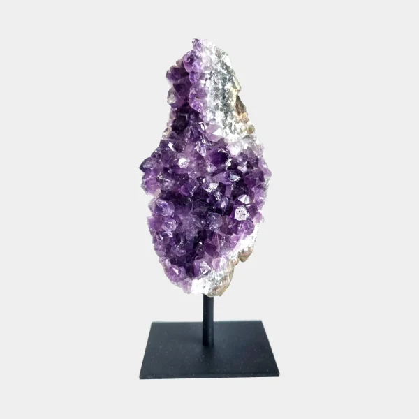 Front view of an amethyst cluster on a black metal stand with deep violet crystals and a tall natural shape.