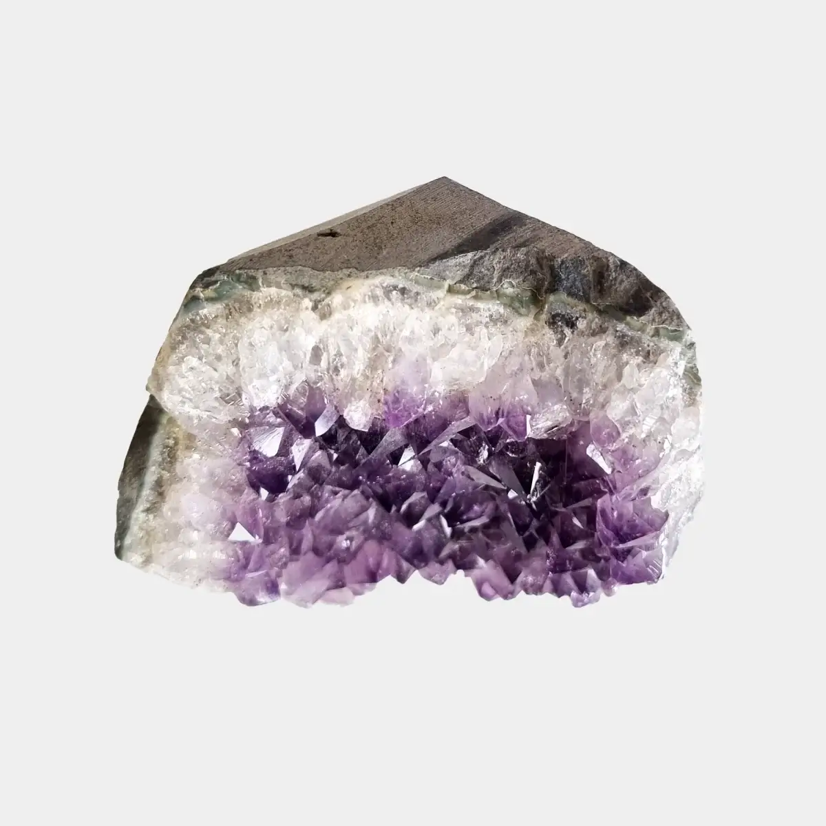 Top view of a small amethyst geode showing the natural stone exterior and a narrow line of crystals.