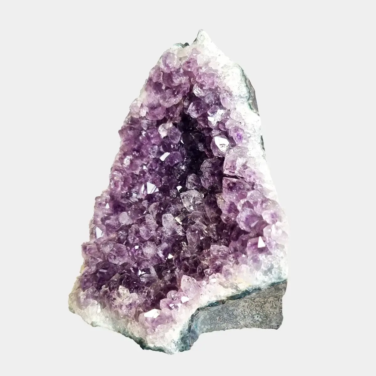 Angled front view of a small amethyst geode with deep violet crystals inside a pale quartz formation.