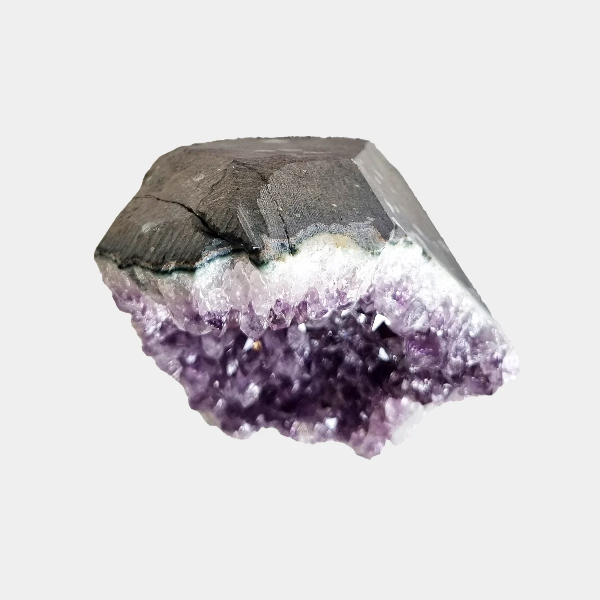 Top view of a small amethyst geode showing the cut stone exterior with amethyst crystals visible along the edge.