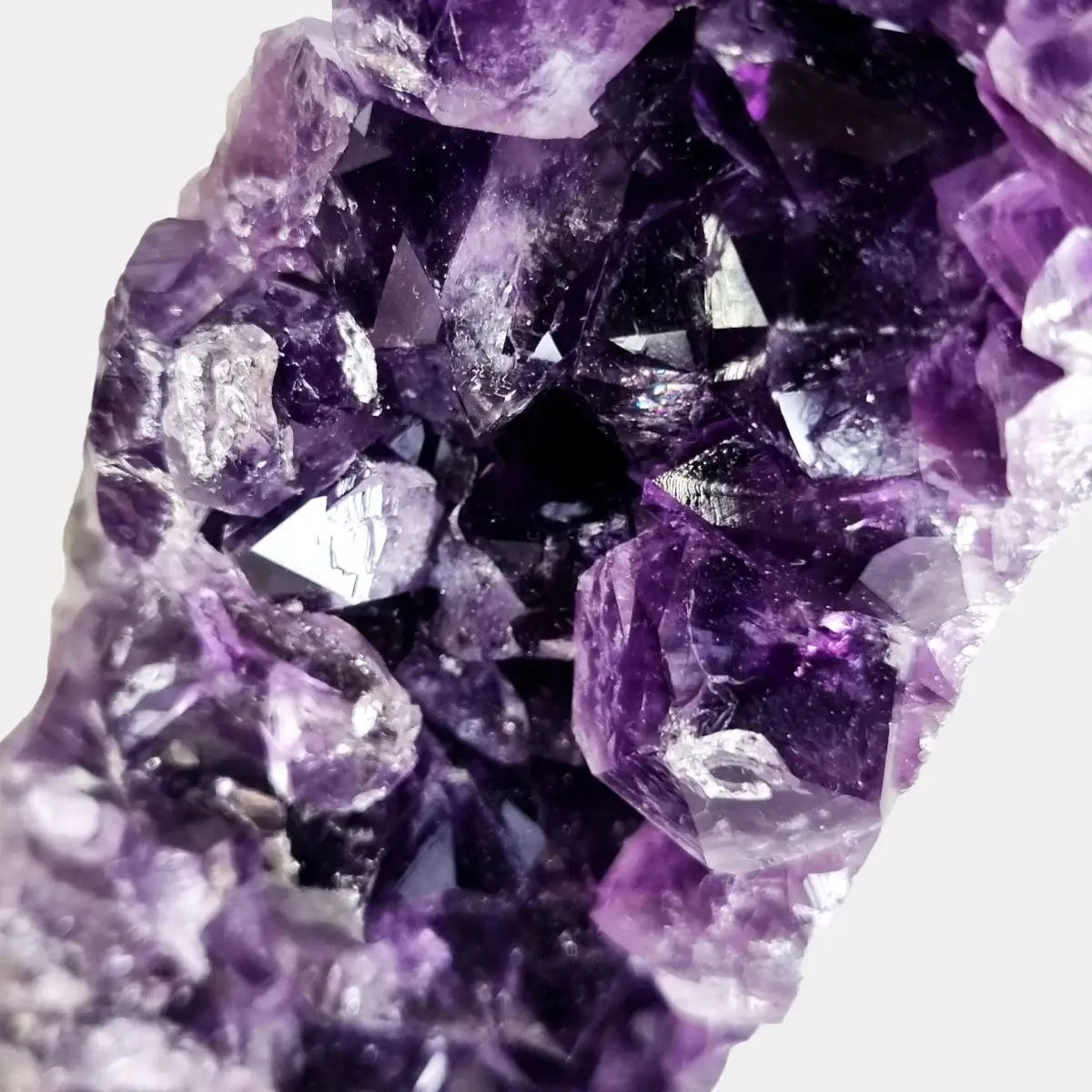 Close-up of deep violet amethyst crystals inside a small geode.