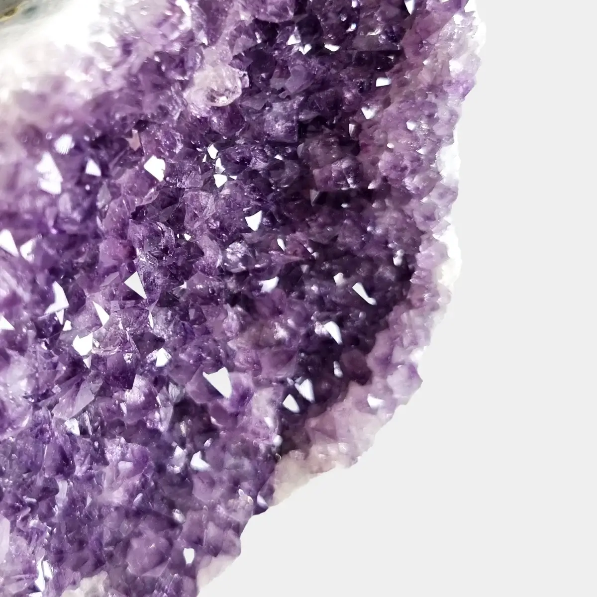 Close-up of small violet amethyst crystals inside a compact geode.
