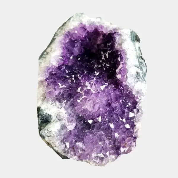 Front view of a small amethyst geode with violet crystals, white quartz edges, and a compact natural shape.