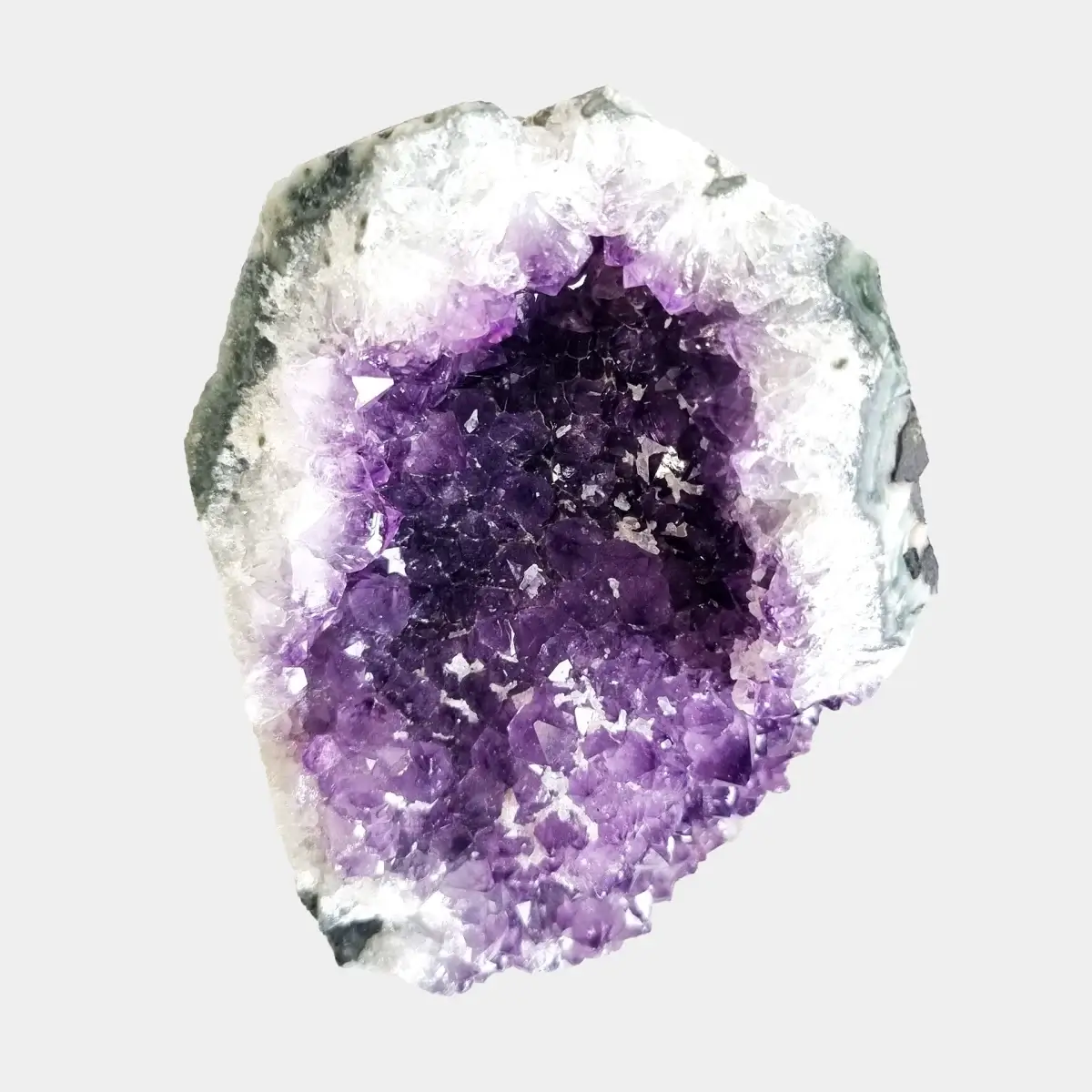 Straight front view of a small amethyst geode with a deep violet crystal centre and pale quartz border.