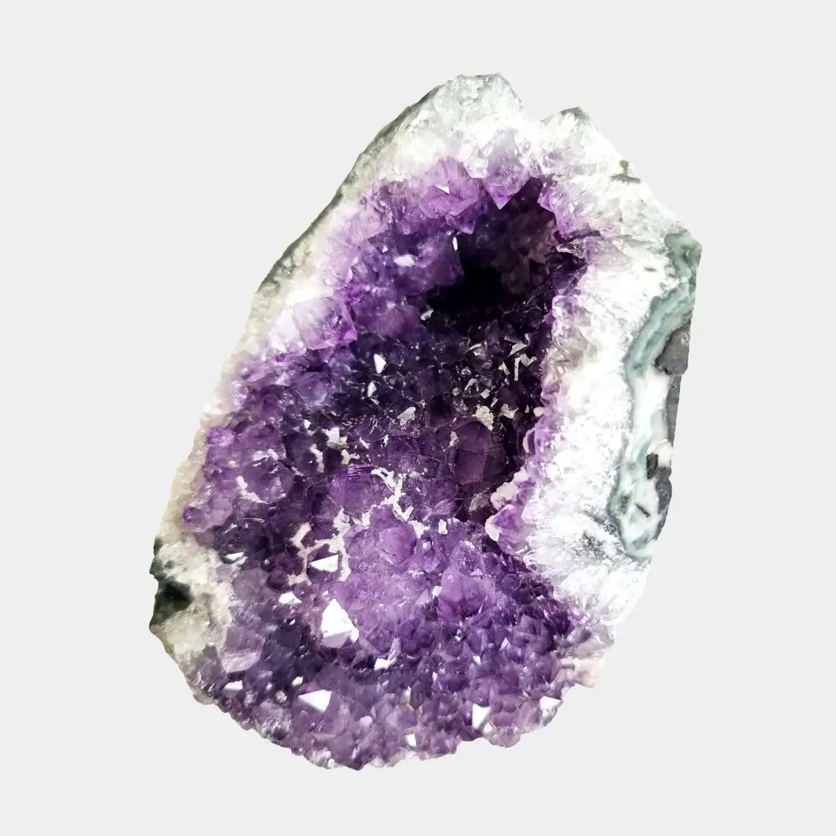 Detailed front view of a small amethyst geode showing purple crystal points inside a pale quartz edge.