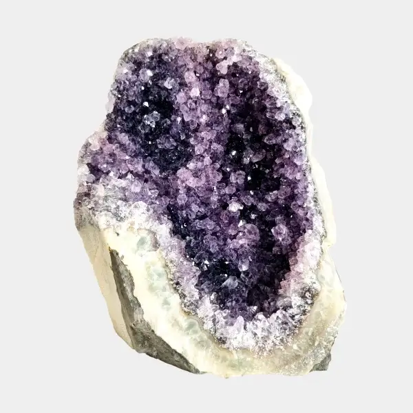 Front view of a small amethyst geode with dark violet crystals, pale quartz edges, and a natural stone base.