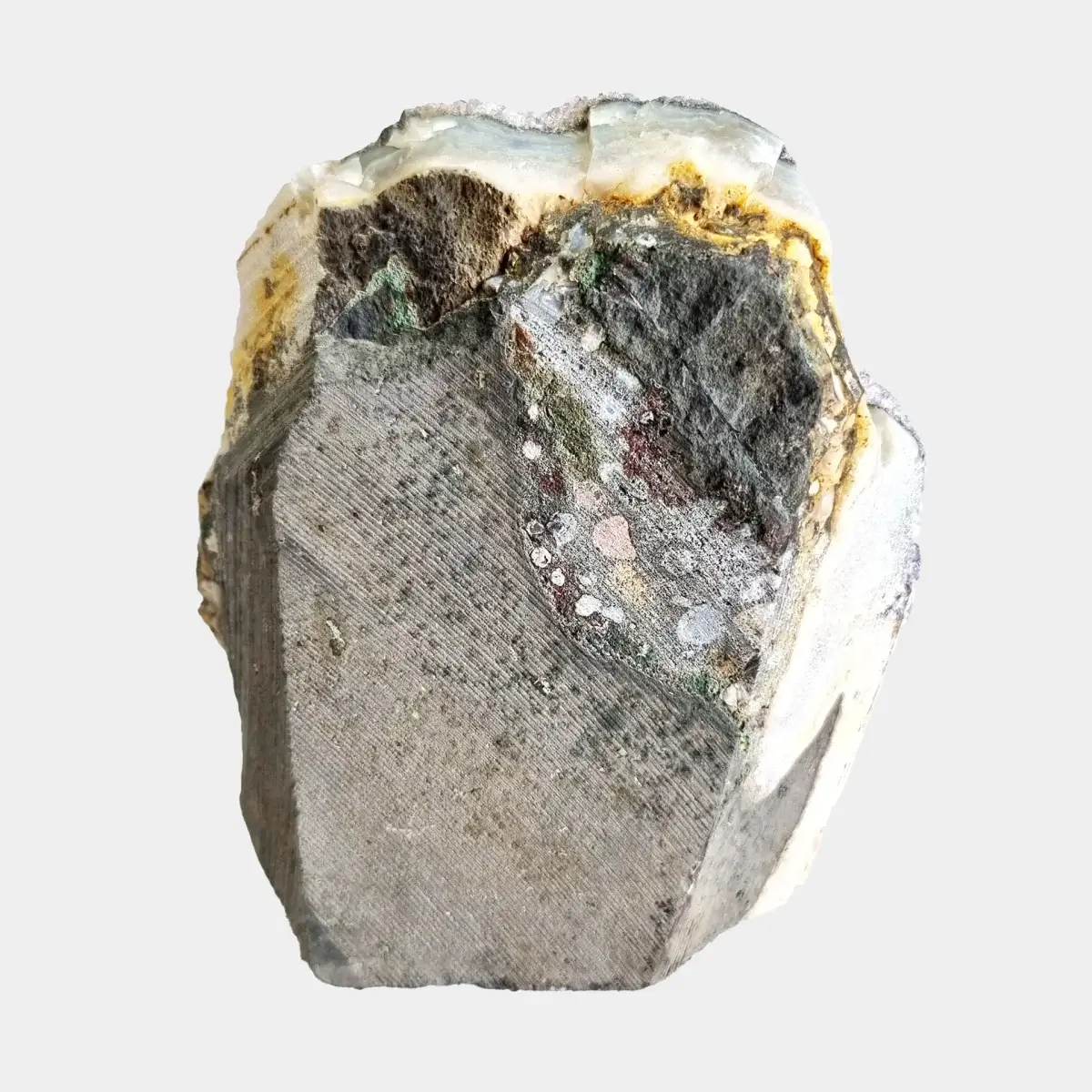 Back view of a small amethyst geode showing the cut natural stone exterior and pale quartz edge.