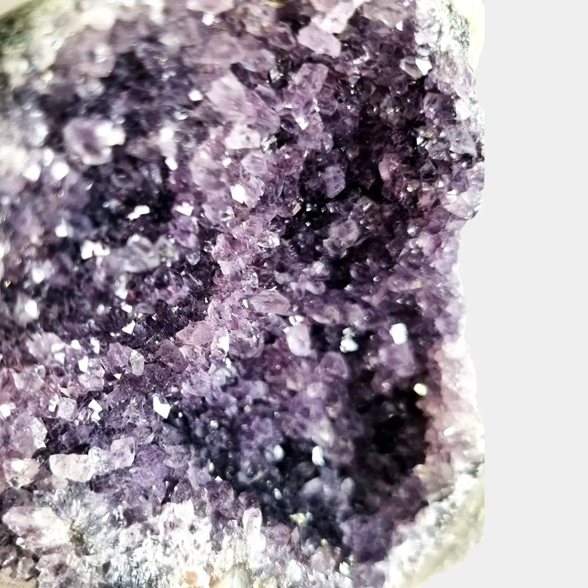 Close-up of dark violet amethyst crystals inside a small geode.